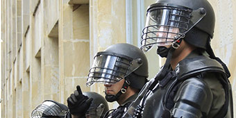 polarisatie betekenis uitgebeeld door politie in beschermde kleding en helm bij rellen