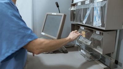 Zorgverlener pakt materiaal uit een voorraadkast